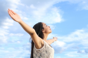 Portrait of a beautiful arab woman breathing fresh air with raised arms